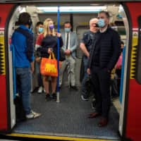 Commuters on a London train on Wednesday. The U.K. the same day reported 6,178 new coronavirus cases, a marked jump in the daily infection rate that comes a day after Prime Minister Boris Johnson unveiled new nationwide restrictions.  | AFP-JIJI