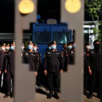 Security officers stand guard as pro-democracy protesters attend a mass rally to call for the ouster of Prime Minister Prayut Chan-ocha and reforms to the monarchy in front of parliament in Bangkok on Thursday. | REUTERS