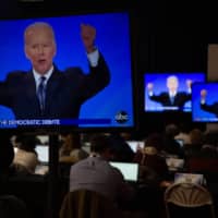 People watch former Vice President Joe Biden during the Democratic presidential debate at Saint Anselm College in Manchester, New Hampshire, on Feb. 7. | ELIZABETH FRANTZ / THE NEW YORK TIMES