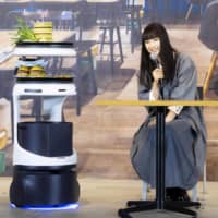 SoftBank Robotics Group Corp.\'s Servi food service robot brings food during its unveiling in Tokyo on Monday. | KYODO