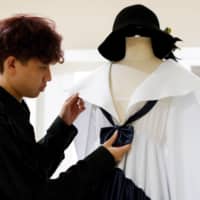 Tin Tunsopon shows one of his creations in his studio.  | REUTERS 