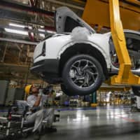 An employee works on a car assembly line at a Dongfeng factory in Wuhan, China, on Sept. 14. | AFP-JIJI
