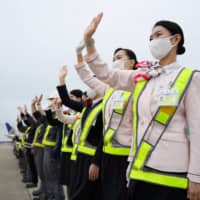 Japan Airlines Co. employees wave to see off a Boeing 767-300ER aircraft at Narita Airport in Chiba Prefecture. | BLOOMBERG