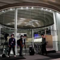Members of the media are seen working at the empty Tokyo Stock Exchange after the TSE temporarily suspended all trading due to system problems in Tokyo on Thursday. | REUTERS