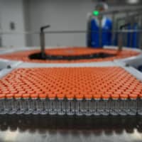 Vials of potential COVID-19 vaccine CoronaVac are seen on the production line at Sinovac Biotech production facility during a media tour on Sept. 24 in Beijing. | GETTY IMAGES / VIA KYODO