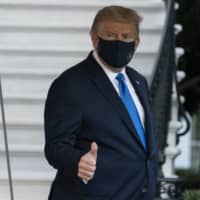 U.S. President Donald Trump gives thumbs up as he leaves the White House to go to Walter Reed National Military Medical Center after he tested positive for COVID-19 on Friday in Washington. | AP