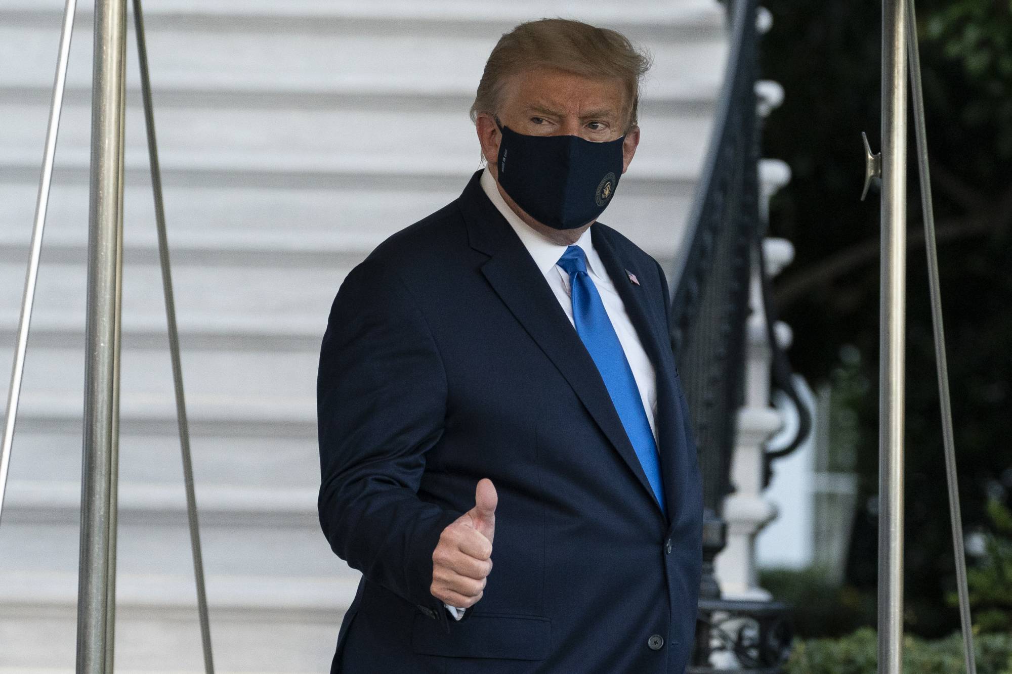 U.S. President Donald Trump gives thumbs up as he leaves the White House to go to Walter Reed National Military Medical Center after he tested positive for COVID-19 on Friday in Washington. | AP