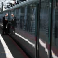 A passenger boards an East Japan Railway Co. bullet train at Tokyo Station. | BLOOMBERG