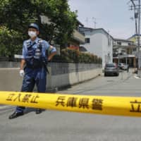 A police line closes off an area where two women were killed by arrows fired from a crossbow in Takarazuka, Hyogo Prefecture, in June. | KYODO