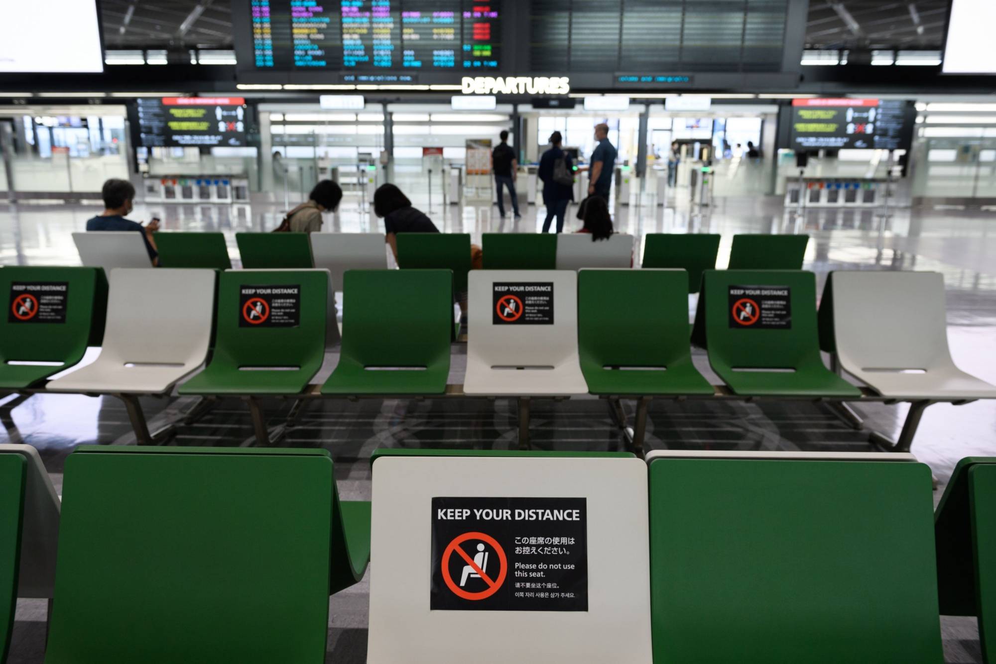 Social distancing signs on benches in the departures hall of Narita Airport in Chiba Prefecture in July | BLOOMBERG