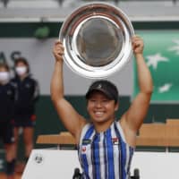 Yui Kamiji lifts the trophy after winning the women\'s wheelchair final at the French Open on Friday in Paris. Kamiji defeated Momoko Ohtani in an all-Japanese final. | AP