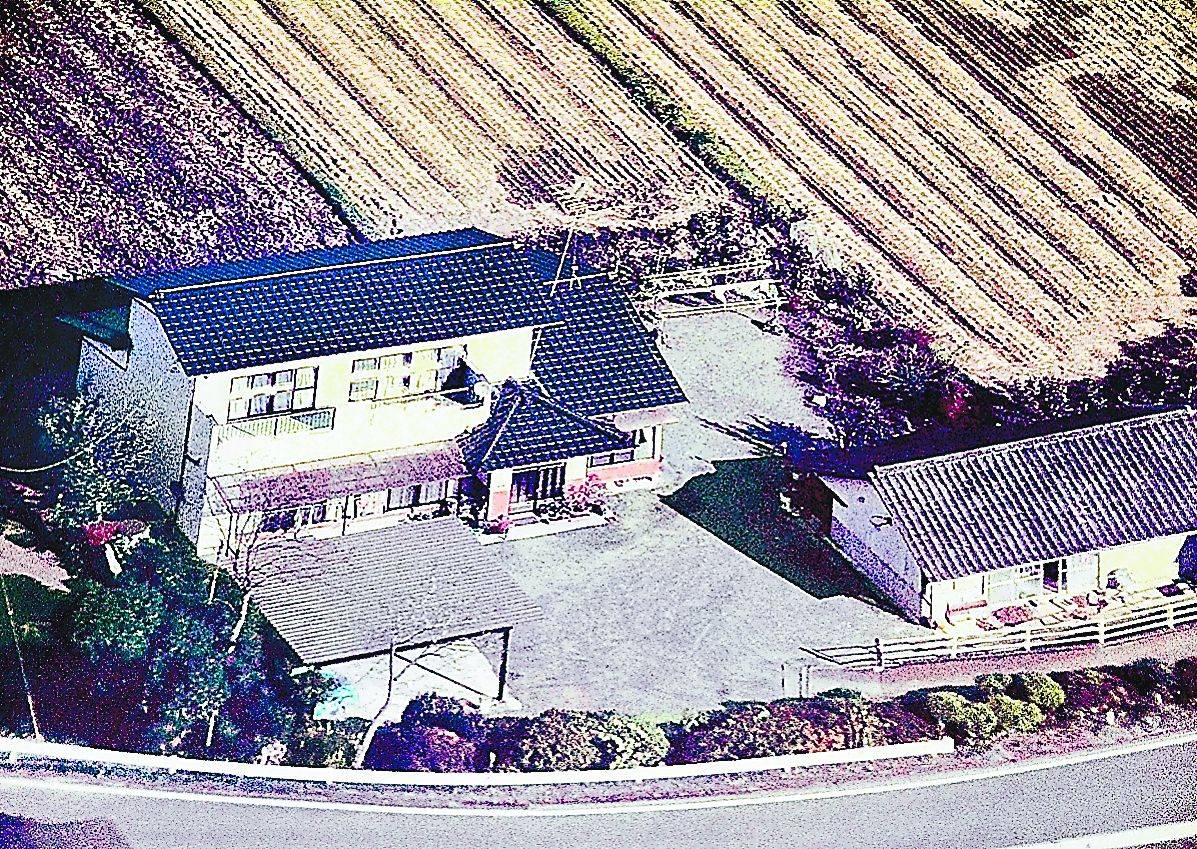 A September 2009 photo shows the home of Takashi Asano in Okuma, Fukushima Prefecture. The house is now a wreck with a damaged roof and is accessible to wild animals. | FUKUSHIMA MINPO