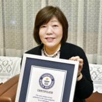 Award-winning Japanese author Mariko Hayashi holds her certificate from the Guinness World Records in Kofu, Yamanashi Prefecture, on Saturday.  | BUNGEI SHUNJU / VIA KYODO