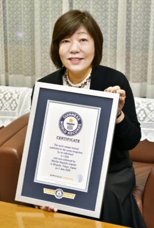 Award-winning Japanese author Mariko Hayashi holds her certificate from the Guinness World Records in Kofu, Yamanashi Prefecture, on Saturday. | BUNGEI SHUNJU / VIA KYODO
