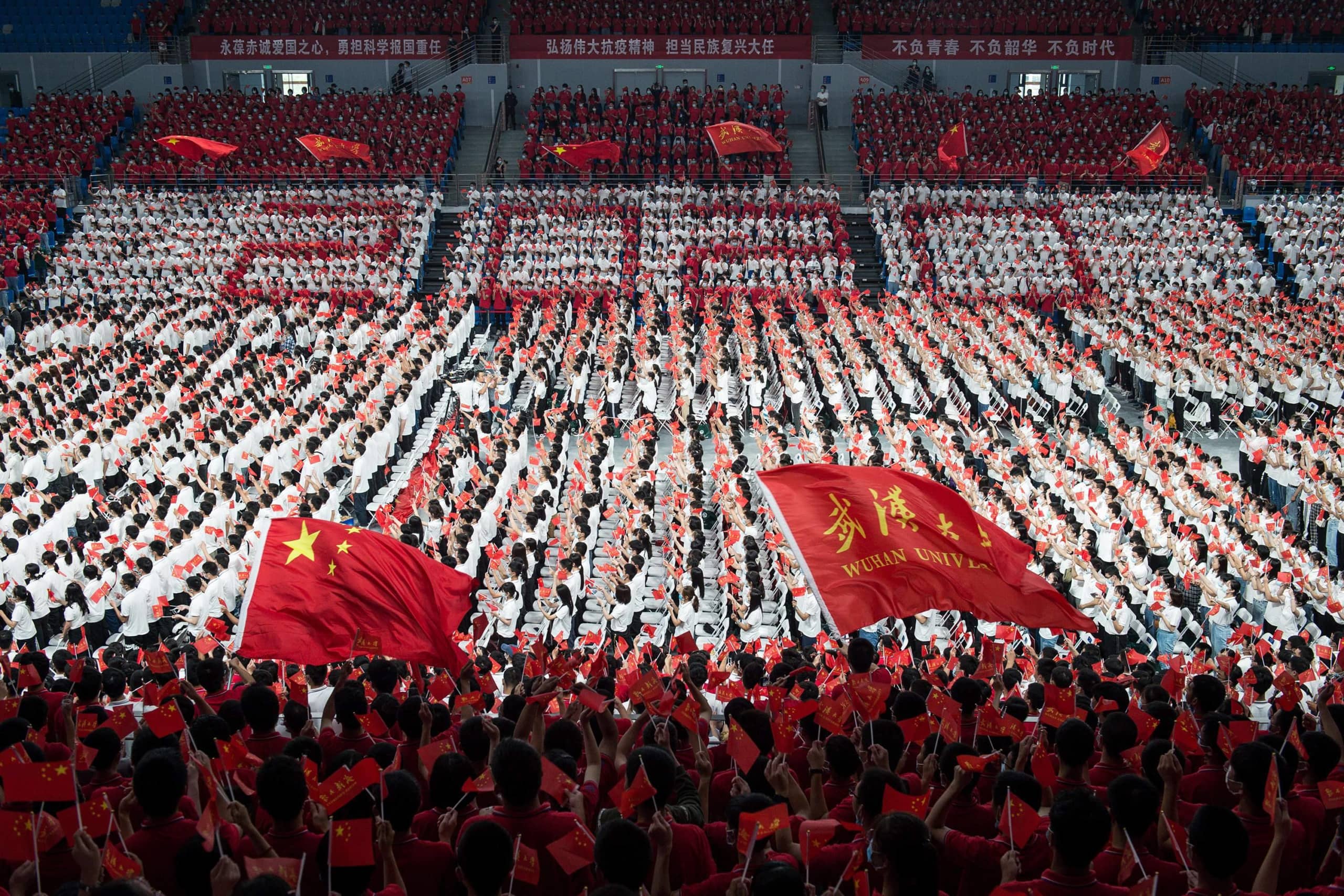 First-year students wave Chinese flags during a commencement ceremony in China's Hubei province last month. | AFP-JIJI