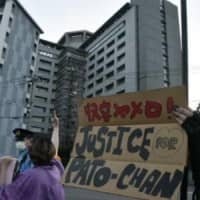 Fight for change: Demonstrators walk past the Tokyo Regional Immigration Services Bureau in Minato Ward. 