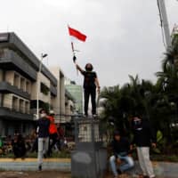 A demonstrators protest against the new so-called omnibus law in Jakarta on Tuesday. | REUTERS