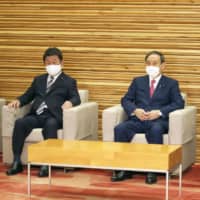 Prime Minister Yoshihide Suga (center) poses for a photo before a Cabinet meeting at the Prime Minister\'s Office Friday. | KYODO