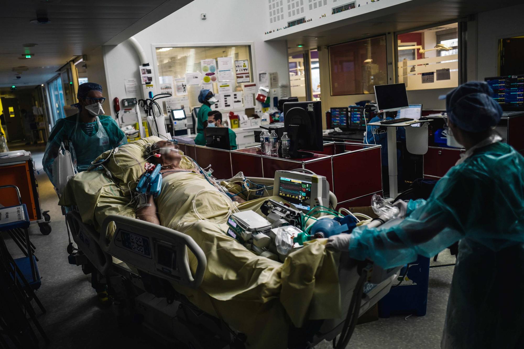 Medical workers transport a patient in the intensive care unit of Lariboisiere Hospital in Paris on Wednesday. | AFP-JIJI