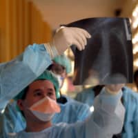 Hong Kong doctor Yuen Kwok-Yung (left) examines patient records at Hanoi\'s Paediatrics Hospital in 2004. Yuen and other doctors from Hong Kong were in Vietnam to help stop a bird flu epidemic.  | REUTERS