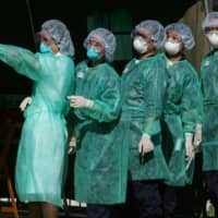 Health workers participate in a SARS outbreak drill in Hong Kong in 2004.  | REUTERS 