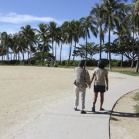 Two women walk on a near-empty Waikiki Beach in Honolulu on Oct. 2. | AP