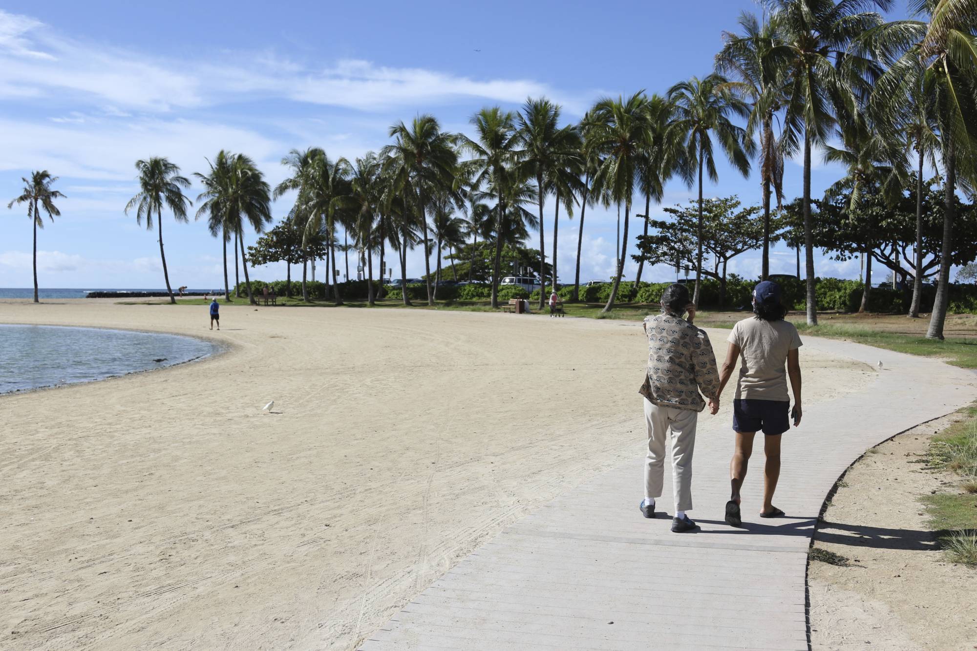 Two women walk on a near-empty Waikiki Beach in Honolulu on Oct. 2. | AP