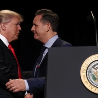 U.S. President Donald Trump shakes hands with TV producer Mark Burnett after being introduced during the National Prayer Breakfast in Washington, D.C., in 2017. | BLOOMBERG