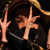 A demonstrator wears a hat with chicken feet attached, a symbol of the Thai protest movement\'s three-finger salute, during an anti-government protest in Bangkok on Wednesday. | REUTERS