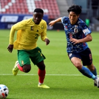 Japan\'s Genki Haraguchi (right) competes against Cameroon\'s Collins Fai during a friendly in Utrecht, Netherlands, on Oct. 9. | REUTERS