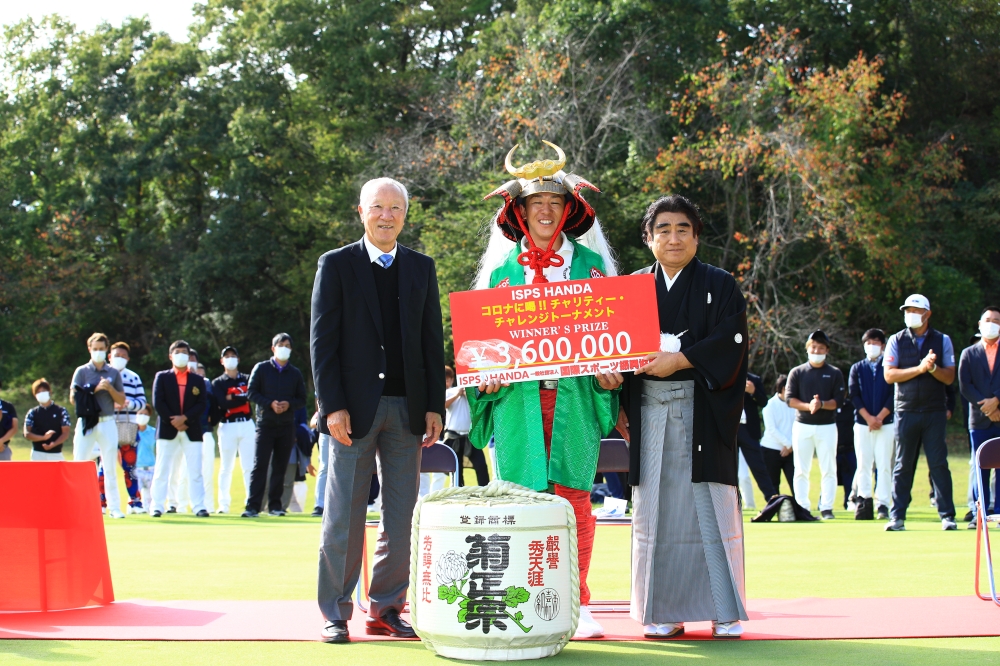 Isao Aoki (left), professional golfer and the chairman of JGTO, and Haruhisa Handa, founder and chair of ISPS Handa, present the awards to winner Kunihiro Kamii (center).