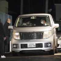 A car believed to be carrying Kazuo Sato, arrested on suspicion of abandoning a dismembered body in an apartment in Kashiwazaki, Niigata Prefecture, arrives at a police station in the city early Friday. | KYODO