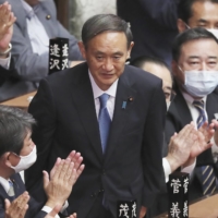 Yoshihide Suga is applauded in the Lower House of the Diet after being elected prime minister on Sept. 16. | AP