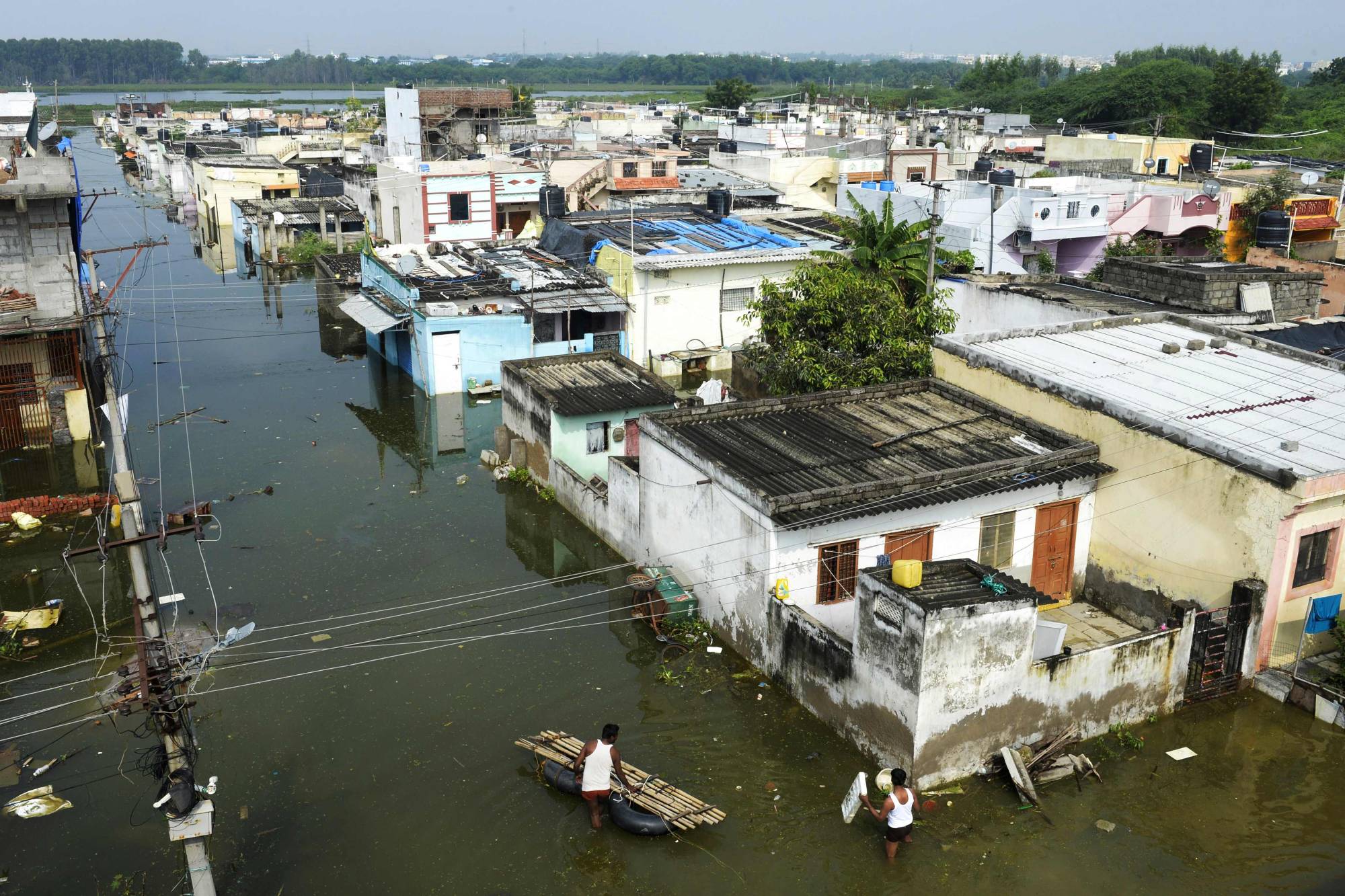 Flood-affected residents search for their belongings following heavy rains on the outskirts of Hyderabad, India, on Tuesday. | AFP-JIJI