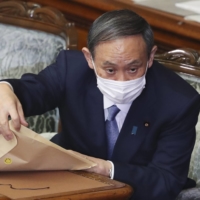 Prime Minister Yoshihide Suga attends an extraordinary Diet session at the Upper House of the Diet in Tokyo on Monday. | AP