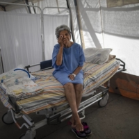 A 76-year-old COVID-19 patient wipes away tears at a public hospital in Caracas.  | AP