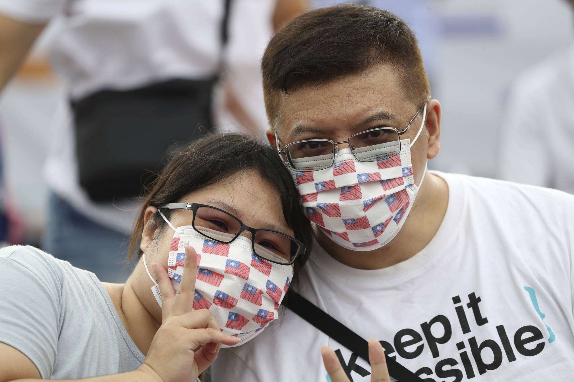 People wearing masks printed with Taiwan's national flag during National Day celebrations in Taipei earlier this month.  | AP