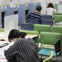 Job seekers wait their turn for consultations at a HelloWork job center in Tokyo in August. | KYODO