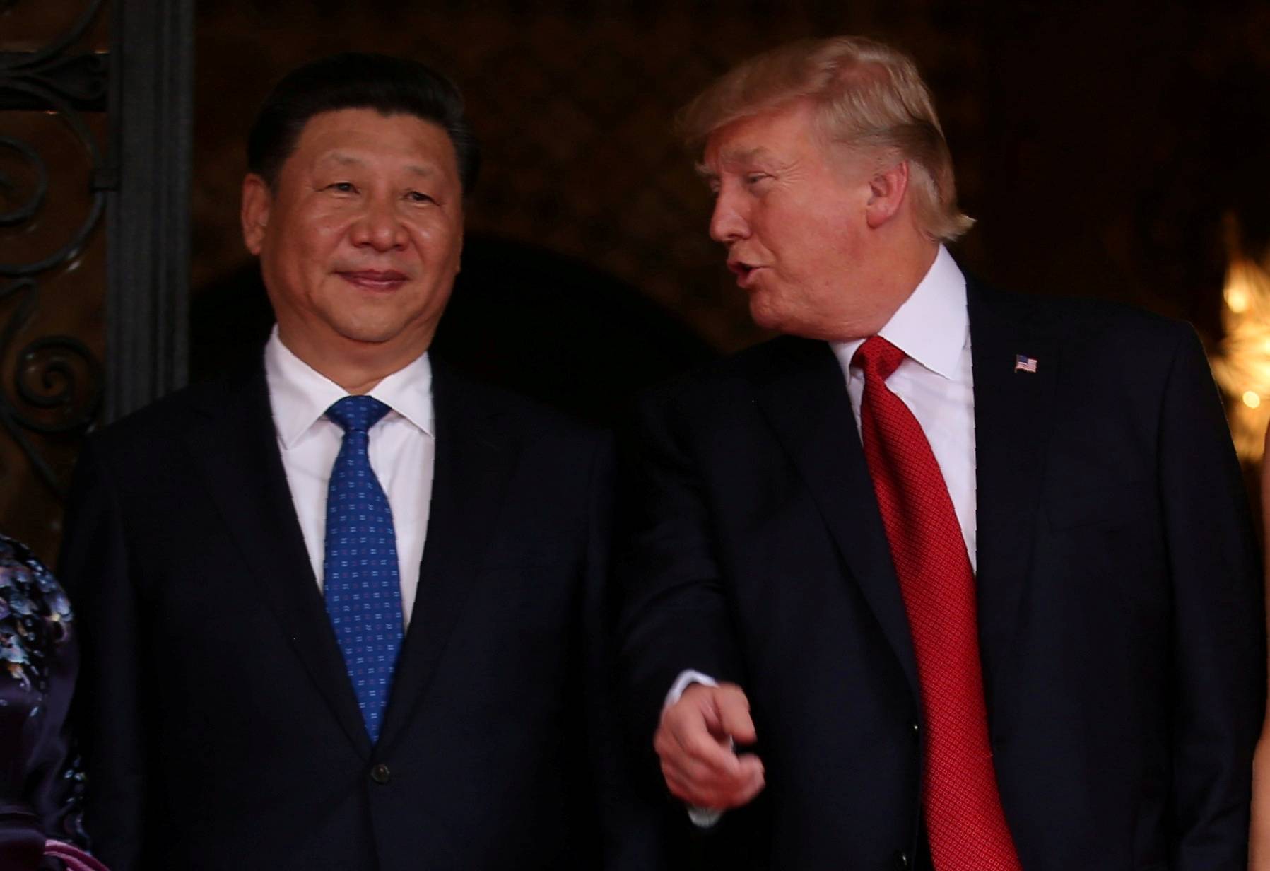U.S. President Donald Trump talks with Chinese President Xi Jinping at the start of their summit in Florida in April 2017. | REUTERS