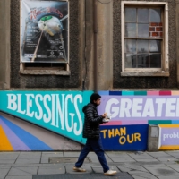 A pedestrian walks past the Arts Theatre in Nottingham, England, as the city headed into the highest level of coronavirus restrictions on Friday. | BLOOMBERG