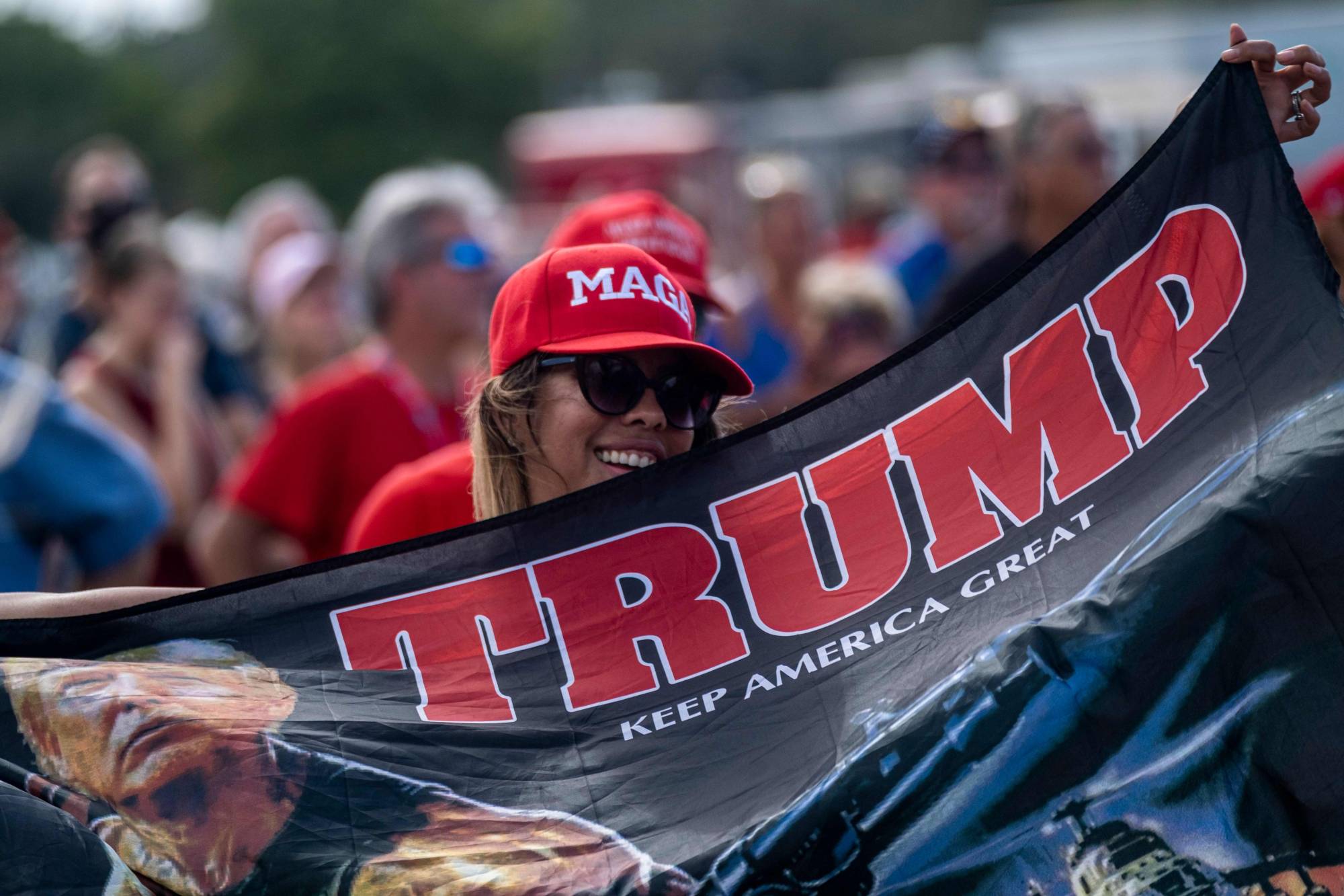 A Donald Trump supporter listens to the U.S. president speak at a rally in Tampa, Florida, on Thursday. At the ideological level, a U.S. election meltdown featuring bitter political clashes and endless litigation would be a propaganda bonanza for the Chinese Communist Party. |  AFP-JIJI