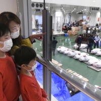 Visitors watch a tuna auction at Toyosu fish market on Monday as public viewing of the event resumed after an eight-month hiatus. | KYODO