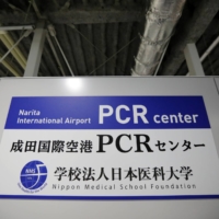 A sign board is displayed at the newly opened Narita International Airport PCR Center operated by Nippon Medical School Foundation. | REUTERS