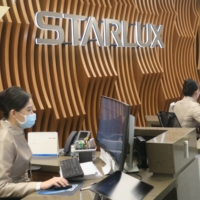 Employees of StarLux Airlines Co. work at the booking counter of the company\'s Taipei office on Tuesday. The company said it is ready to start operating flights from Taiwan to Japan next month. | KYODO
