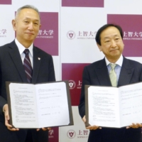 Sophia University President Yoshiaki Terumichi (left) signs an agreement with Hello Work Shinjuku in Tokyo on Nov. 5. | KYODO
