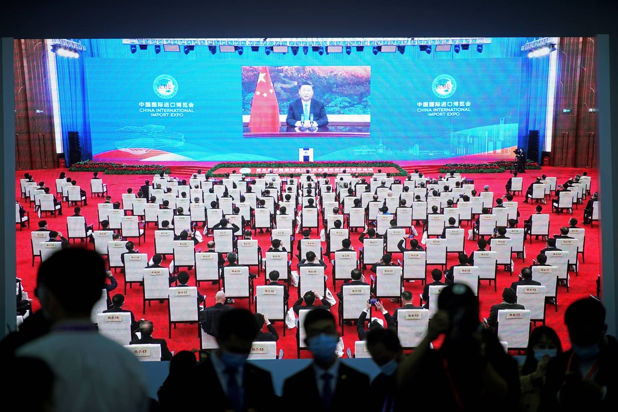 China's President Xi Jinping is seen on a screen in the media center as he speaks at the opening ceremony of the third China International Import Expo in Shanghai on Wednesday. | REUTERS