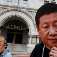 Protesters wear a face masks of China\'s President Xi Jinping and U.S. President Donald Trump during a demonstration in front of the Trump International Hotel in Washington, D.C. on October. | REUTERS