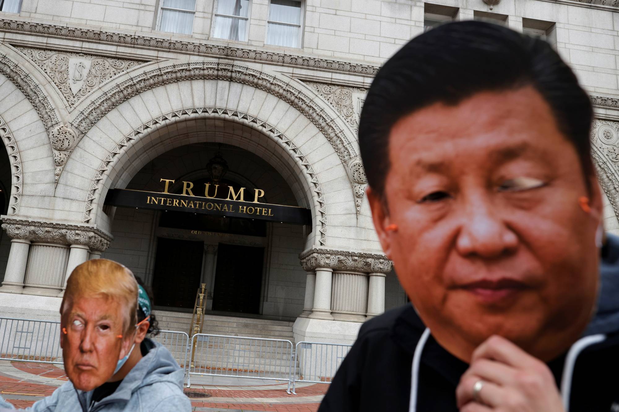 Protesters wear a face masks of China's President Xi Jinping and U.S. President Donald Trump during a demonstration in front of the Trump International Hotel in Washington, D.C. on October. | REUTERS