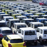 Suzuki Motor Corp. vehicles bound for shipment sit at Nagoya Port in August. Suzuki’s operating profit could continue to recover as its automobile units sales, particularly in core markets such as India and Japan, improve steadily. | BLOOMBERG
