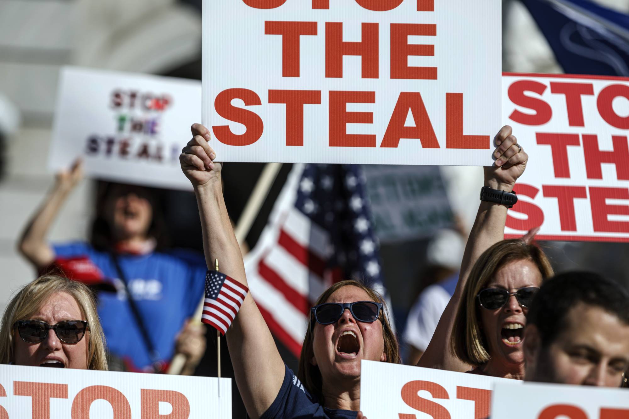 Protesters hold up signs at a pro-Trump rally at the Pennsylvania state Capitol in Harrisburg on Friday. | THE PATRIOT-NEWS / VIA AP.